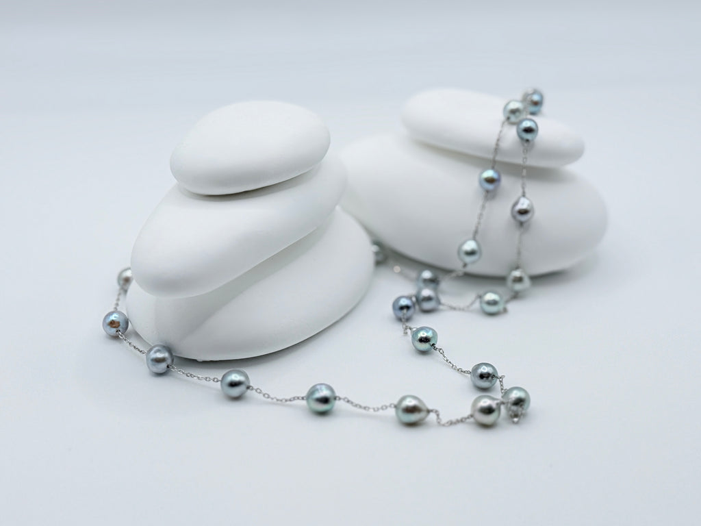 Blue baroque Akoya pearl station necklace 60cm length with 27 pearls displayed on white stones