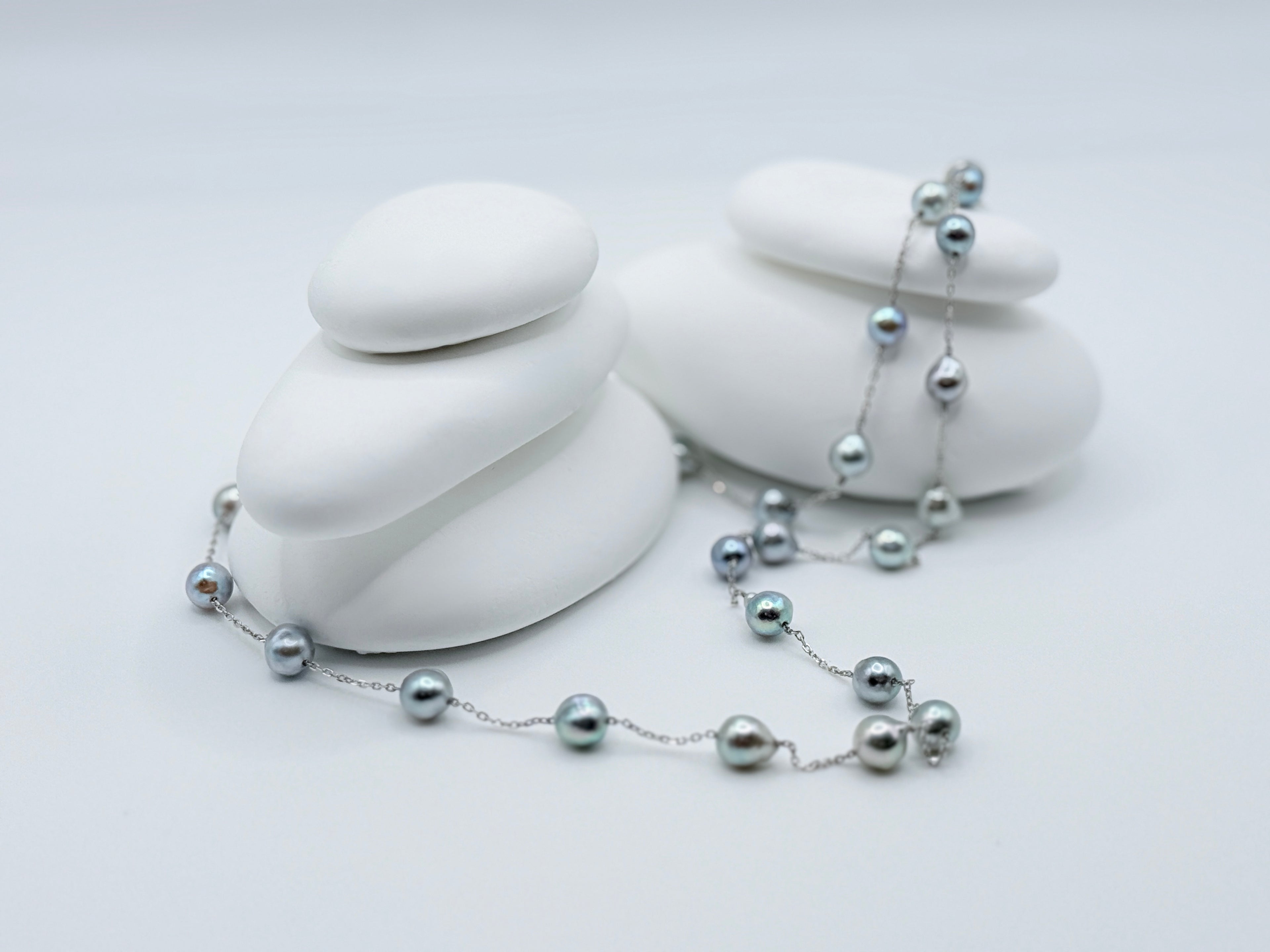 Blue baroque Akoya pearl station necklace 60cm length with 27 pearls displayed on white stones