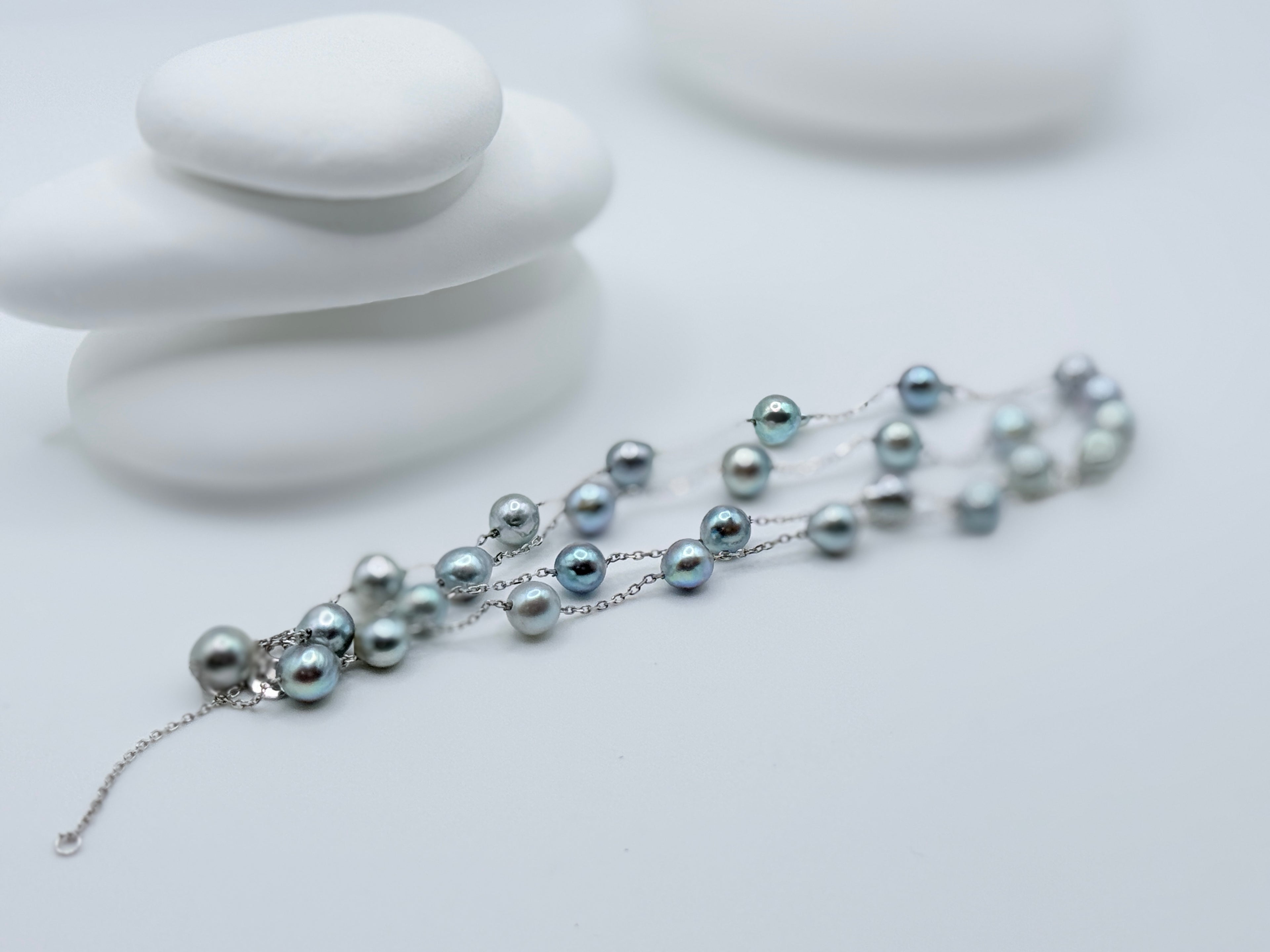 Close-up of blue baroque Akoya pearls 5.5-7.5mm on sterling silver station necklace showing natural lustre and spacing on white stones