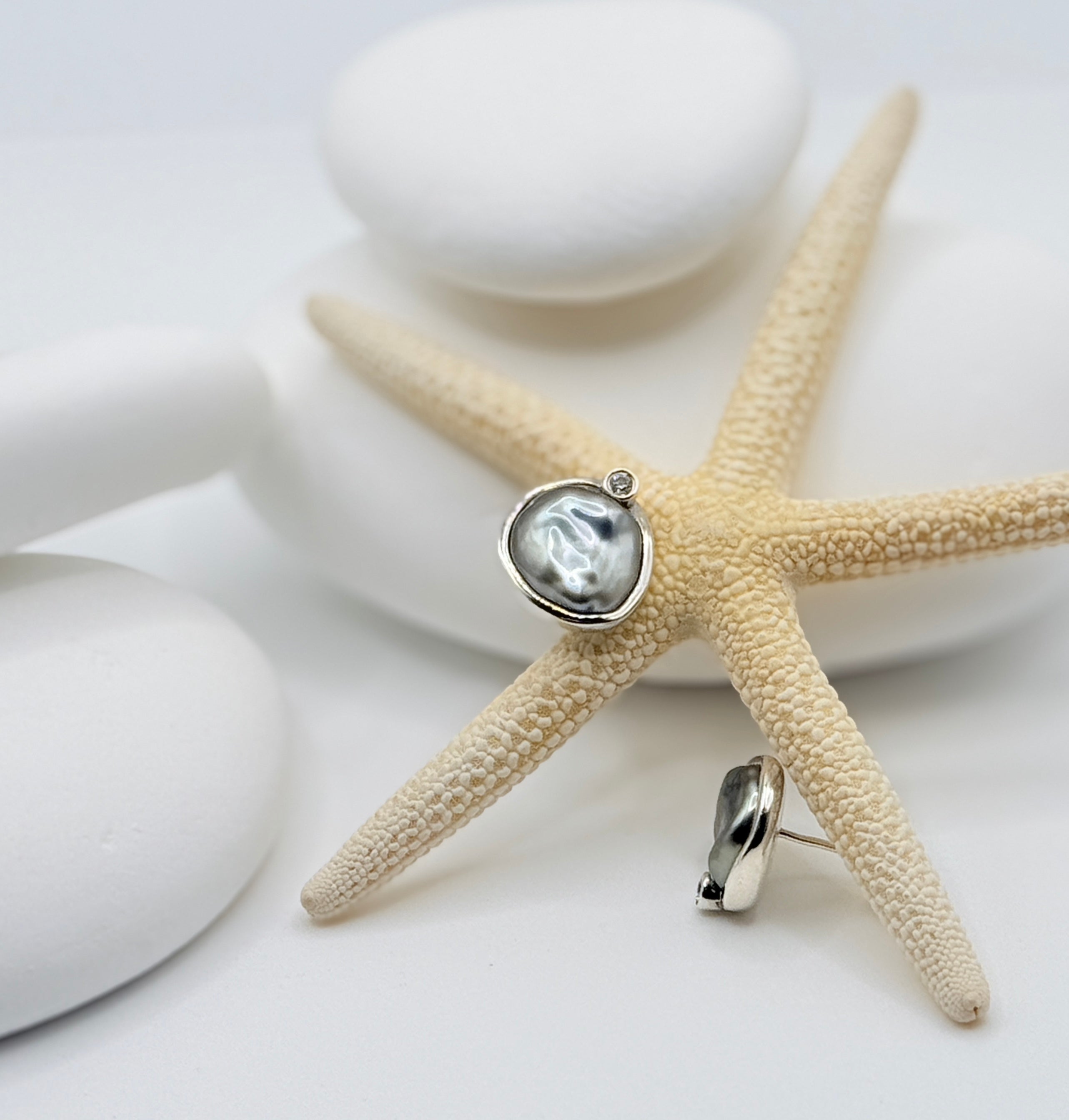 Tahitian keshi baroque pearl stud earrings showing silvery-grey lustre with moissanite detail