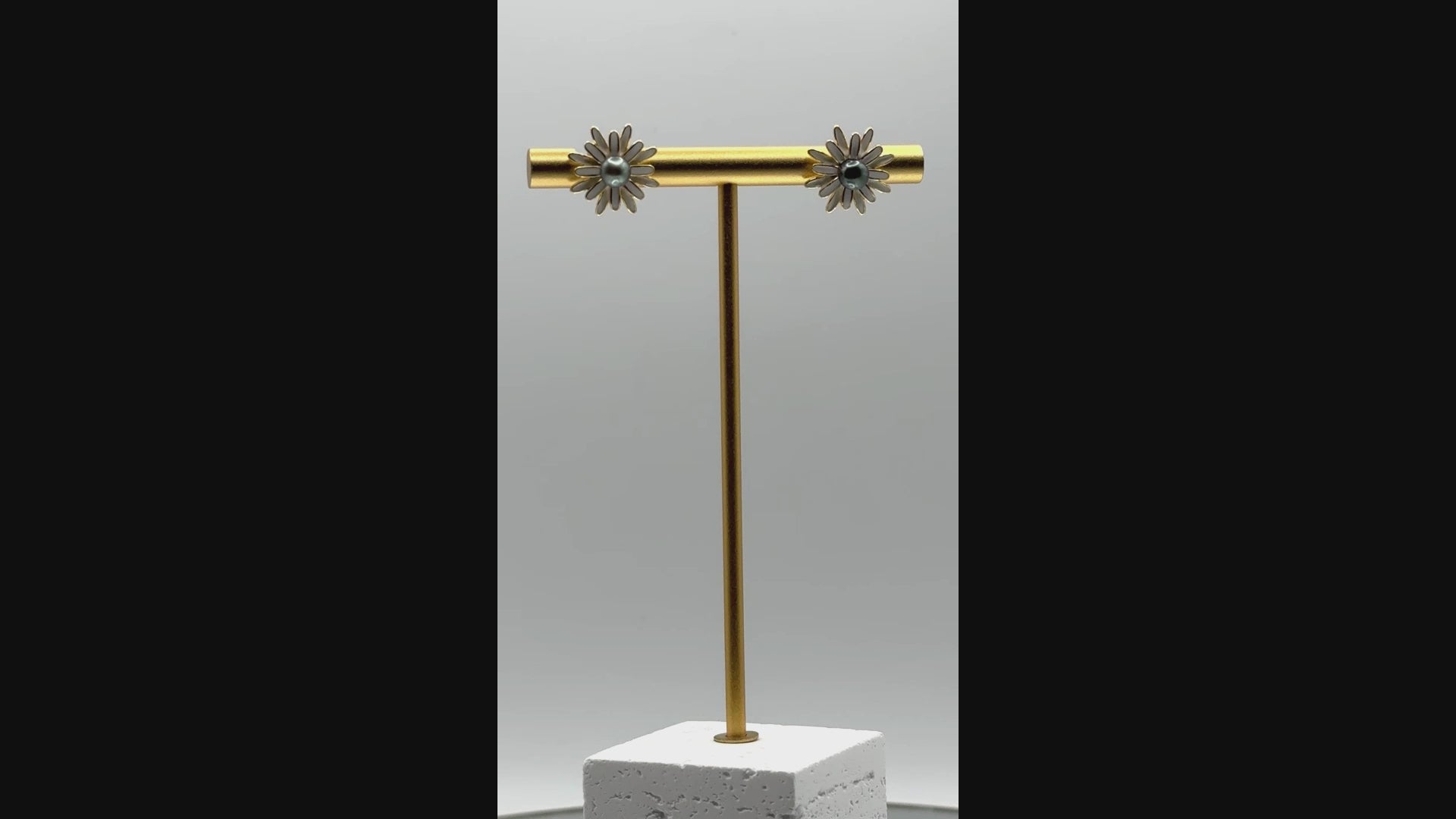 Rotating video of mini daisy earrings showing central Tahitian pearls, enamel petals, and gold-plated settings from all angles