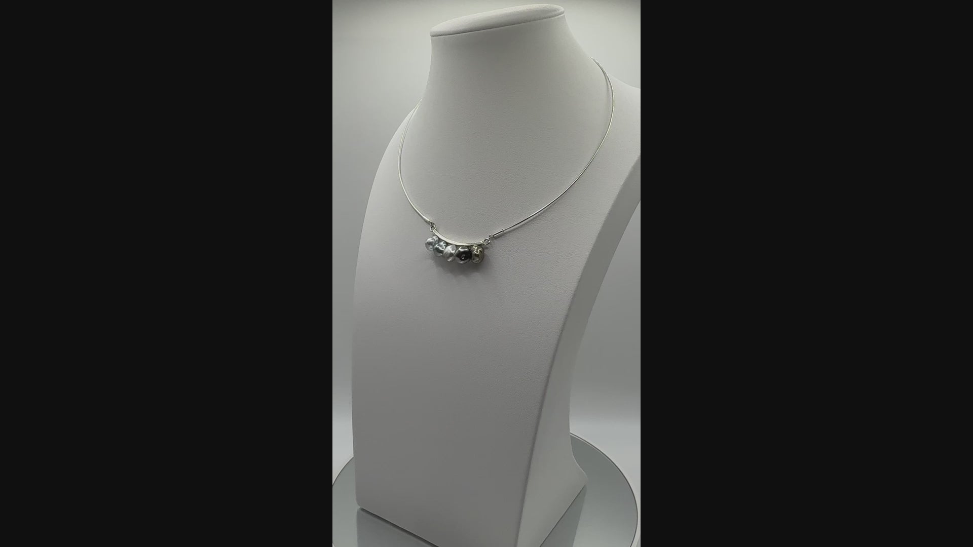 Rotating view of Tooth Fairy necklace on display bust, showing lustrous pearls and modern silver wire structure from multiple angles