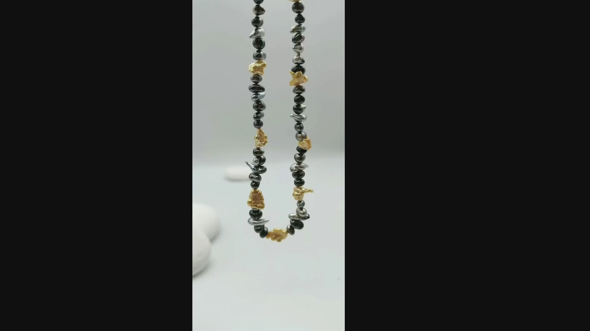 Video of mixed colour 40cm Tahitian keshi pearl strand with gold South Sea pearl spacers suspended in the air showing natural movement