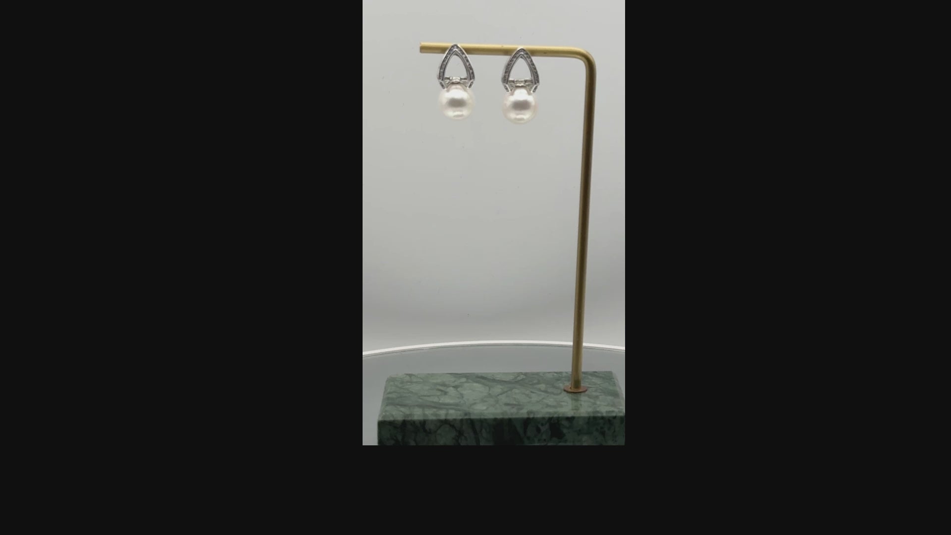 A video showing earring displayed on gold earring stand, rotating showing the style of earring as worn