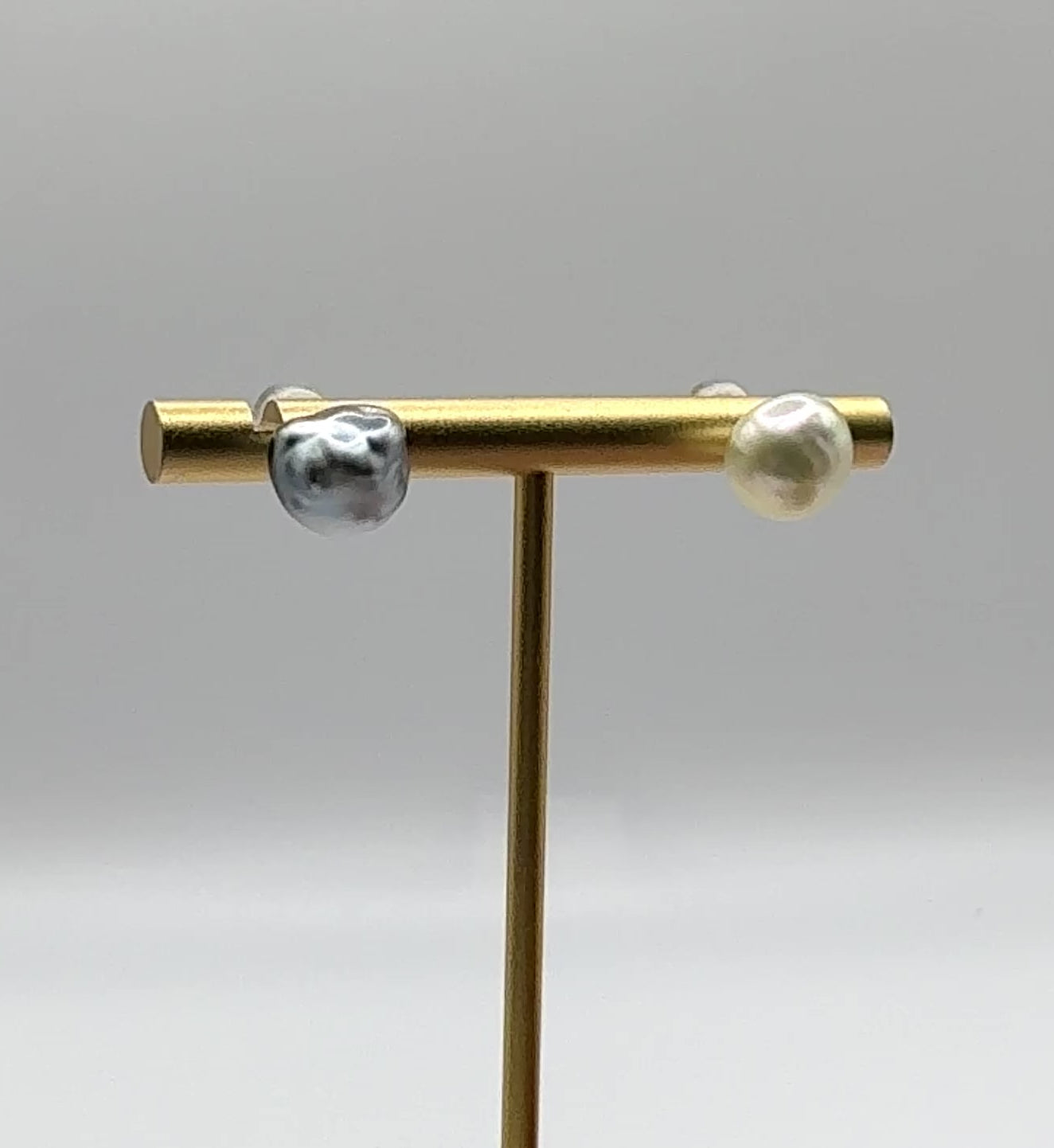 video showing ear studs on display golden bar showing the large size of the pearls