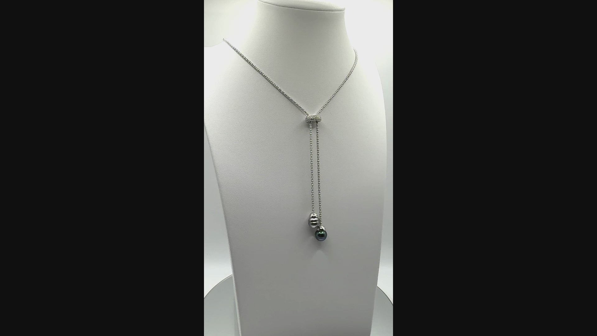 Video showing sterling silver lariat necklace with two Tahitian pearls rotating to display all angles of both pearls and adjustable chain design