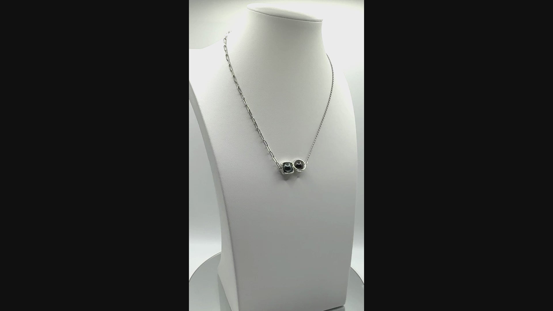 Rotating video of dual Tahitian pearl necklace showing floating bezel design and contrasting chain textures in motion