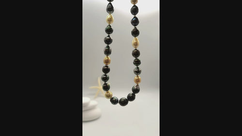 Video of multicoloured baroque pearl necklace suspended and gently moving in the air, displaying the beautiful variety of dark green, black, golden and white baroque pearls in fluid motion