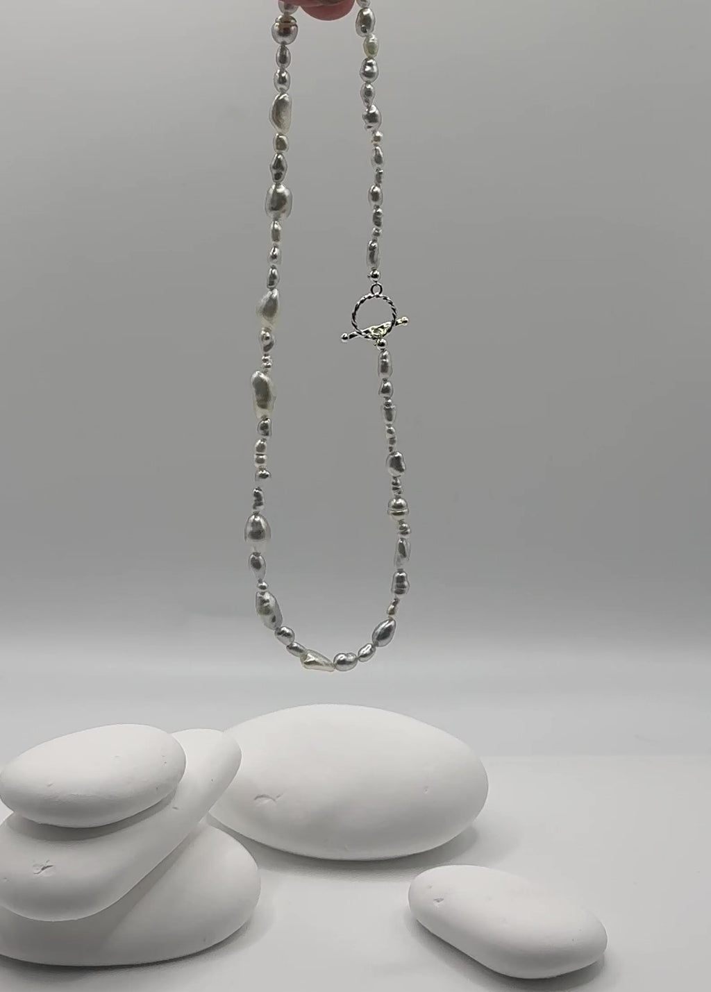 South Sea white keshi strand suspended in air showing natural movement and flow of varied organic shapes with sterling silver OT toggle clasp swaying gracefully 