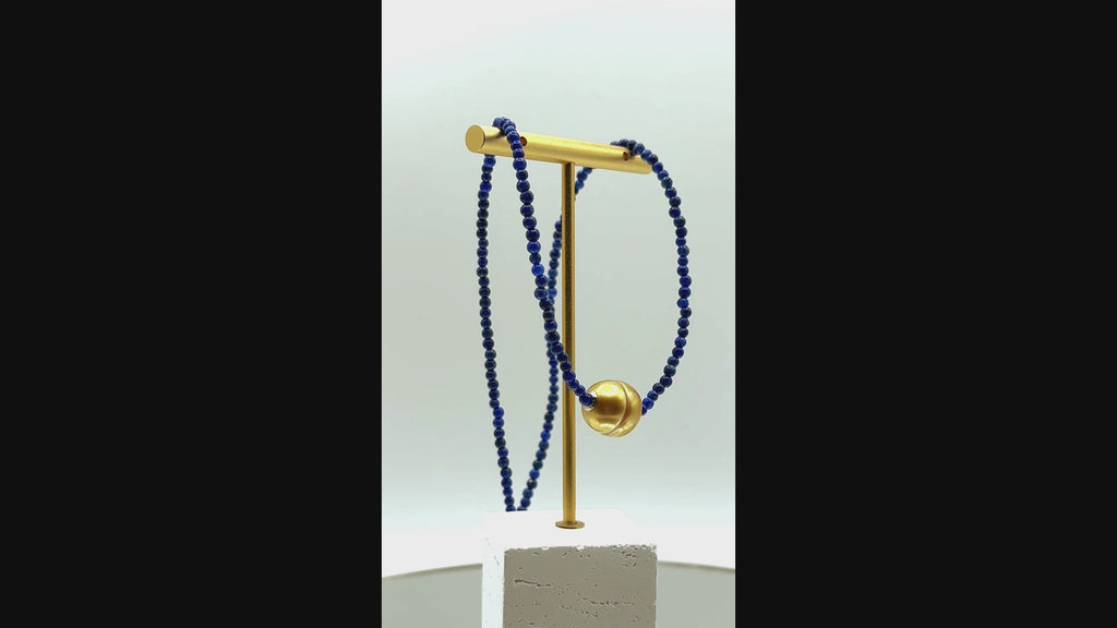Video showing golden South Sea pearl choker with lapis lazuli beads rotating to display all angles of the pearl centrepiece and rich blue gemstone beads
