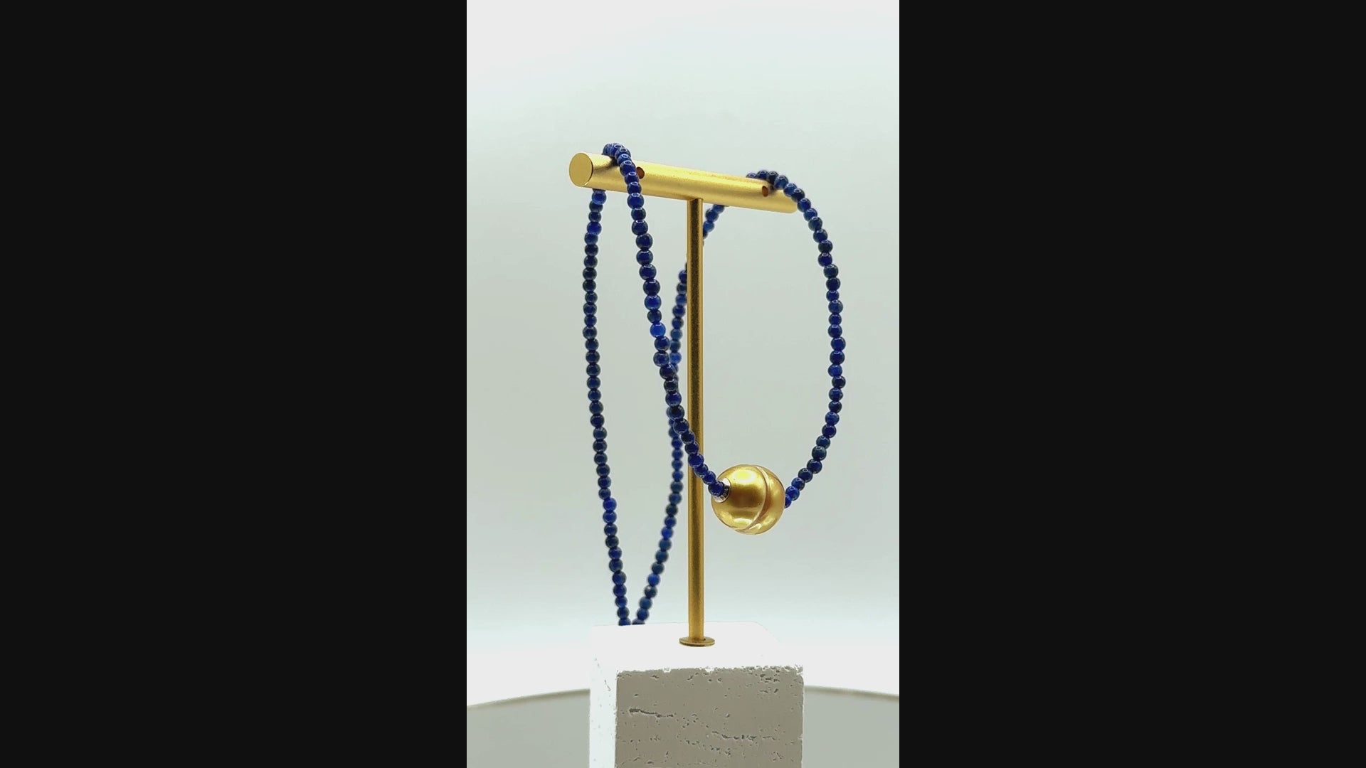 Video showing golden South Sea pearl choker with lapis lazuli beads rotating to display all angles of the pearl centrepiece and rich blue gemstone beads