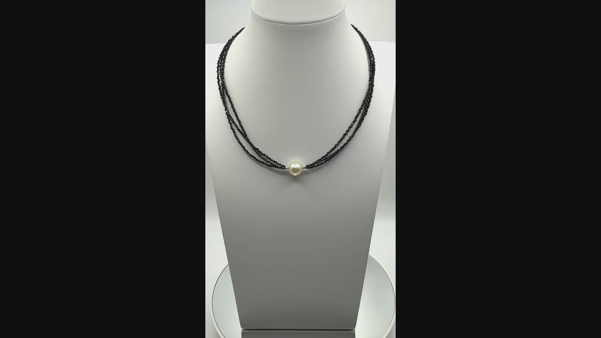 Video of triple-strand black spinel choker with South Sea gold pearl, showing fluid drape, lustre, and detailed sparkle