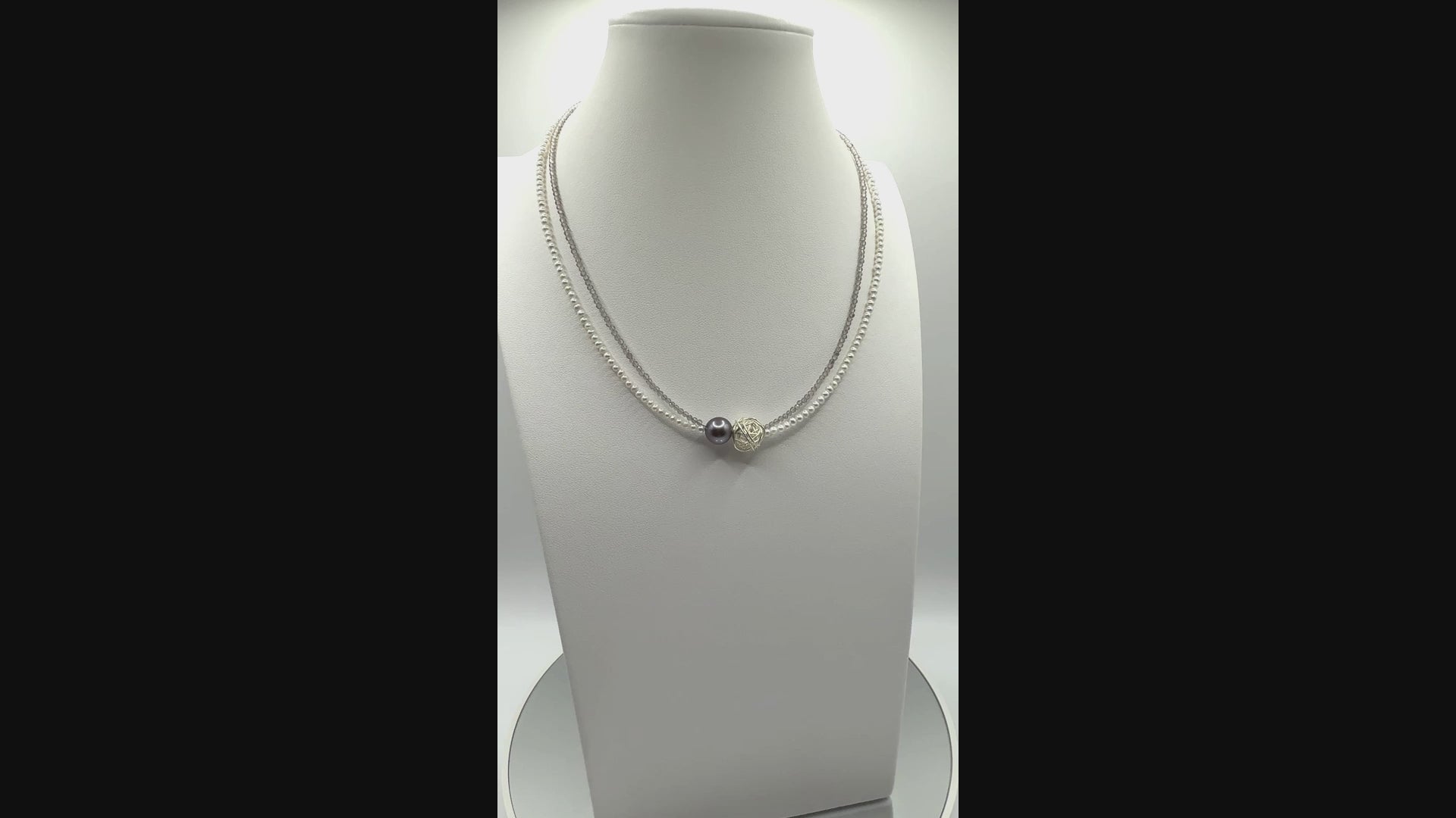 Video showing elegant choker with Tahitian baroque pearl, silver wire-wrapped bead, and white seed pearls rotating to display all angles of the central elements and delicate construction