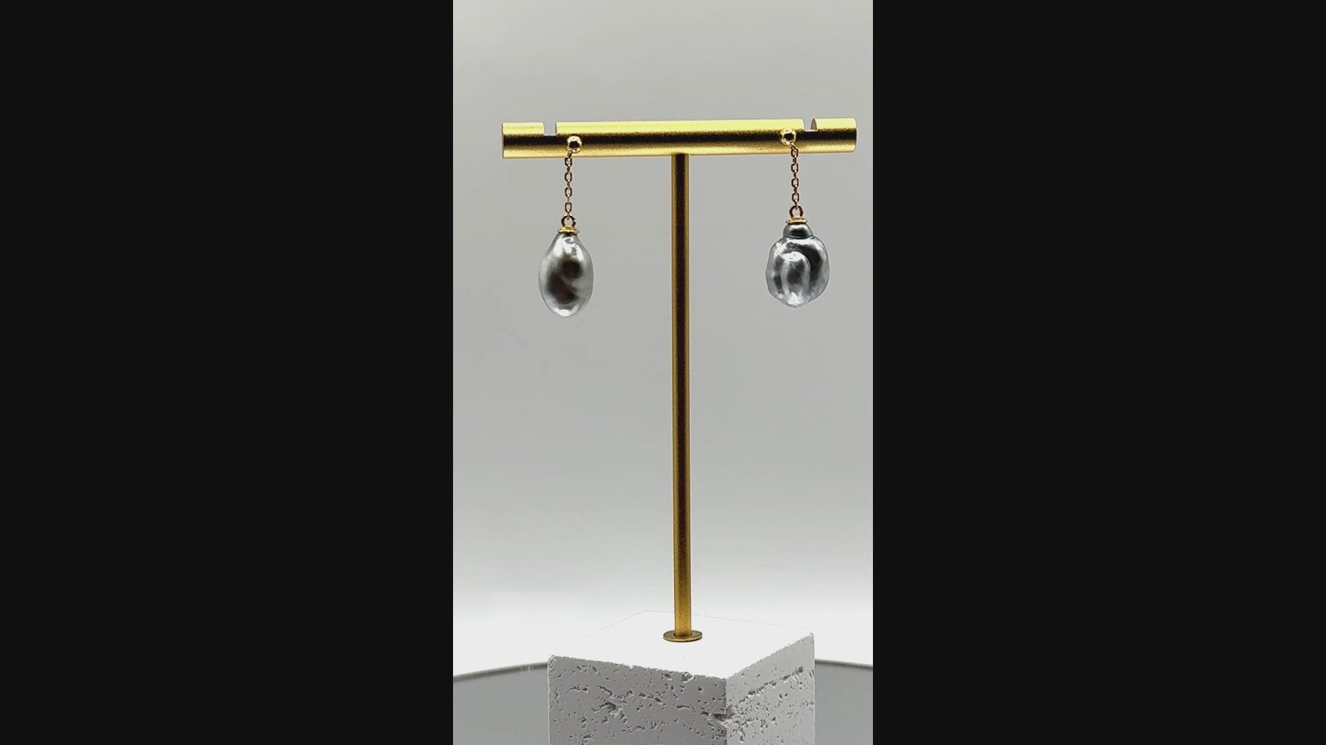 Video showing gold drop earrings with Tahitian keshi pearls rotating to display all angles of the baroque pearls and delicate gold chain construction